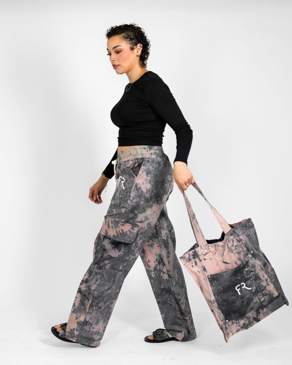 Woman holding a tote bag with a floral pattern on a white background