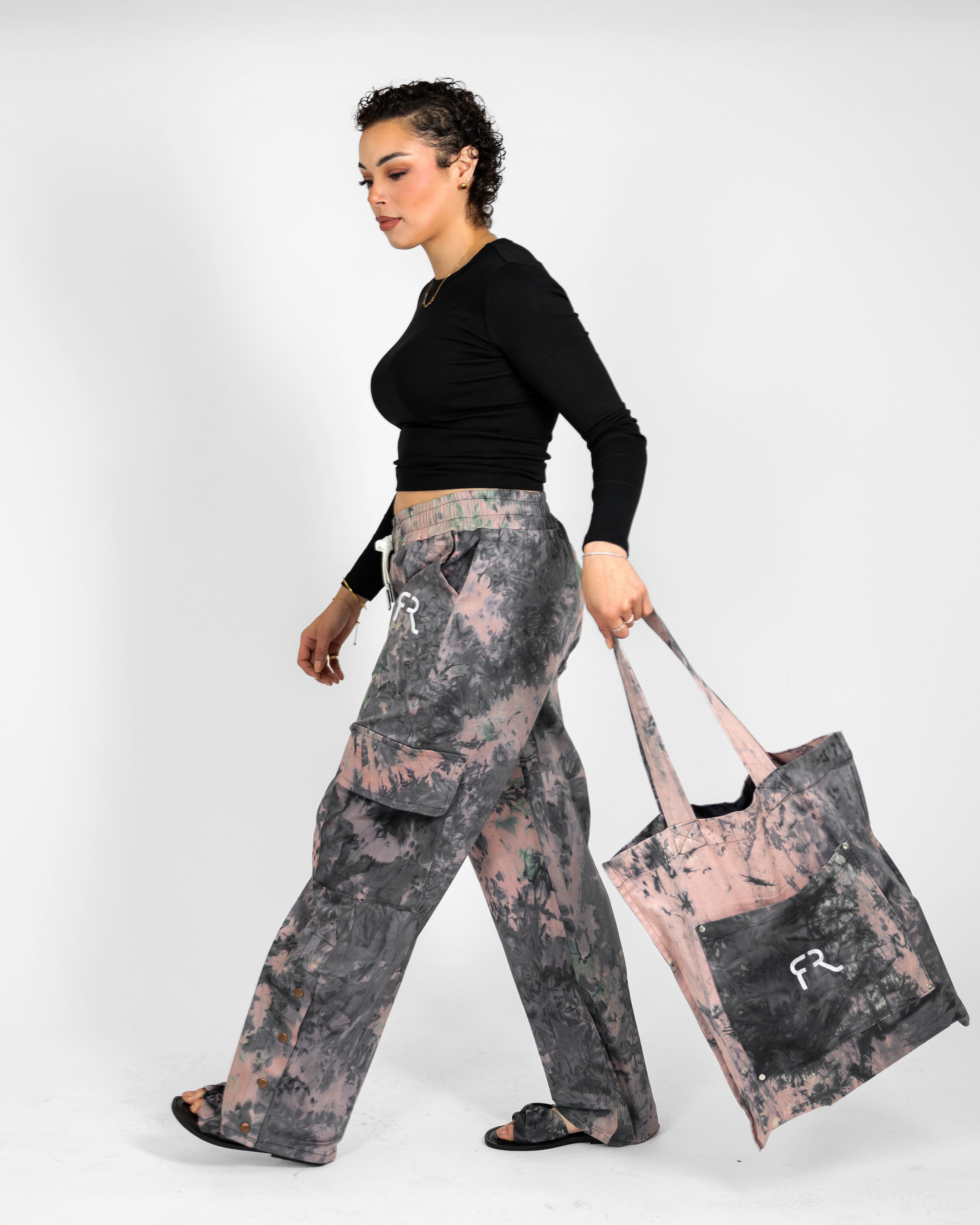 Woman holding a tote bag with a floral pattern on a white background
